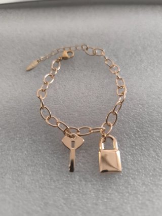 Pulsera dorada con llave y candado