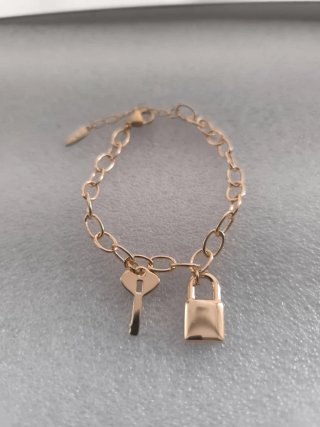 Pulsera dorada con llave y candado
