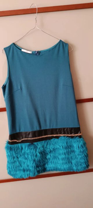 Vestito color avion con pelliccia e catena