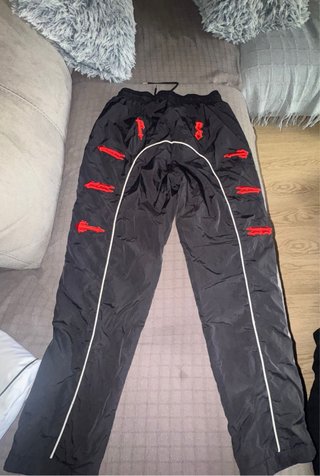 Pantalones negros con detalles rojos