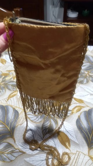 Pochette dorata con frange e perline