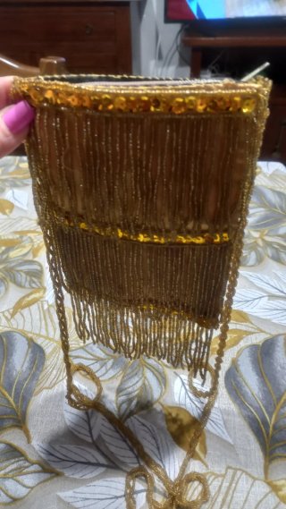 Pochette dorata con frange e perline