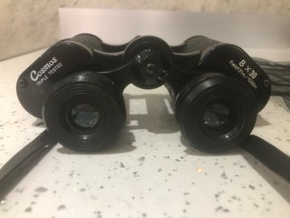 Binocolo nero con tracolla e copriobiettivi
