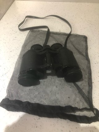 Binocolo nero con tracolla e copriobiettivi