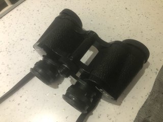 Binocolo nero con tracolla e copriobiettivi