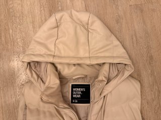 Chaleco acolchado beige con capucha