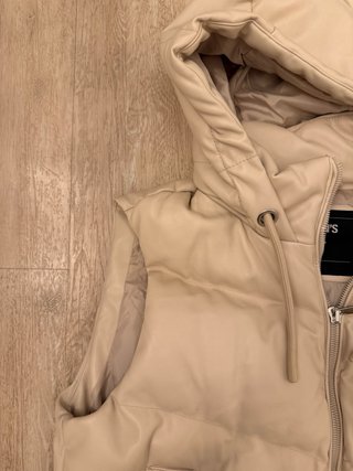 Chaleco acolchado beige con capucha
