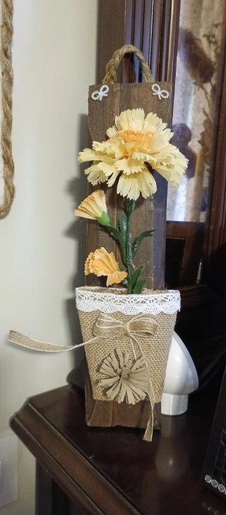Maceta colgante de yute con clavel amarillo