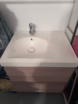 Mueble de baño con lavabo y grifería.