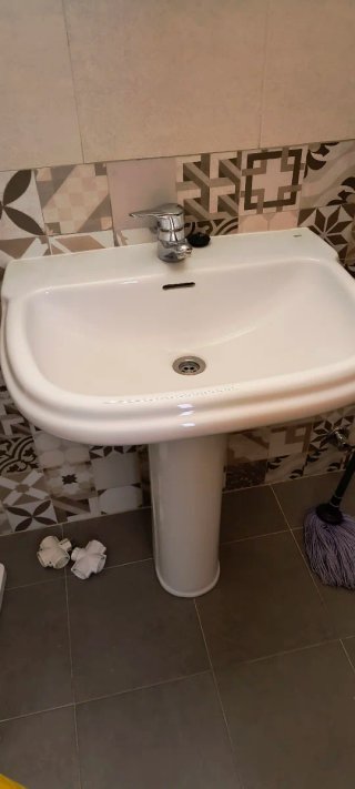 Lavabo de porcelana blanco y grifo de roca