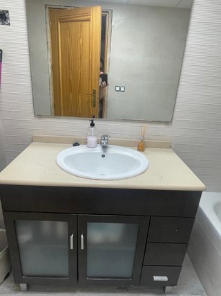 Mueble de baño madera y puertas de cristal.