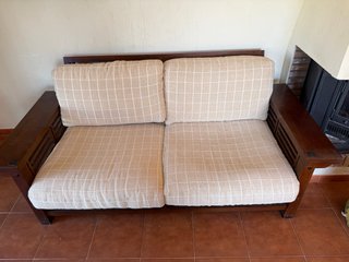 Sofá de madera de teca y tela beige.