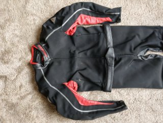 Traje de moto Dainese negro y rojo.