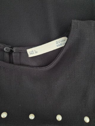 Blusa Sfera negra con volantes y perlas