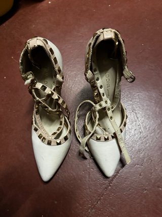Zapatos de tacón blancos con tachuelas doradas