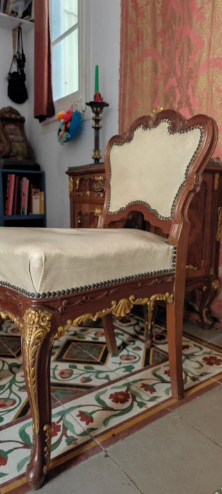 Silla baja antigua de madera y cuero.