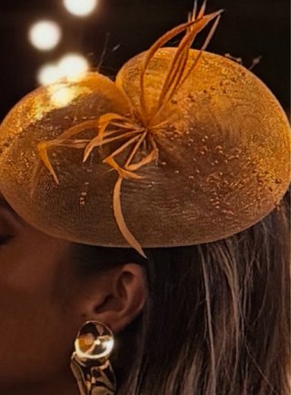 Tocado dorado con plumas y perlas