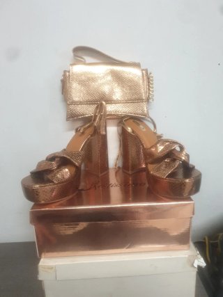 Zapatos de tacón dorados y bolso