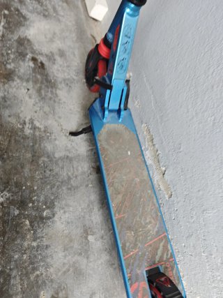 Patinete azul con ruedas rojas