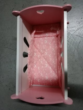 Cuna de madera rosa y blanca para muñecas.