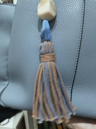 Bolso azul y beige con detalle de borla