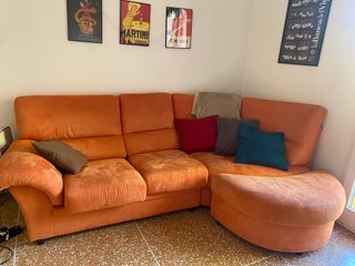 Divano angolare arancione con pouf