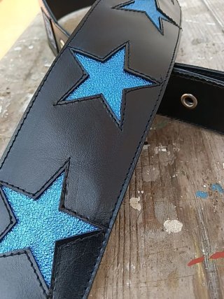 Correa de guitarra negra con estrellas azules