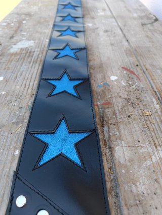 Correa de guitarra negra con estrellas azules