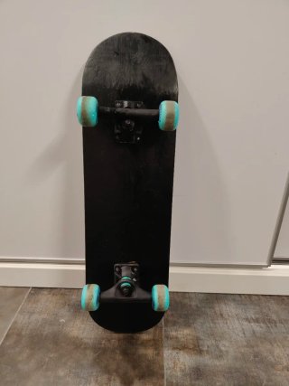 Monopatín negro con ruedas azules