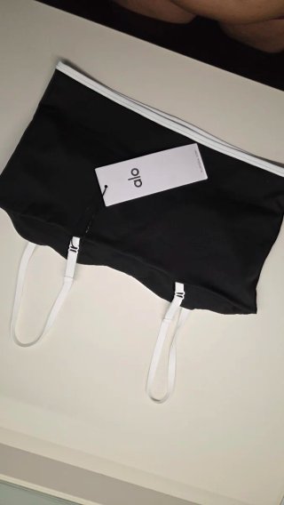 Top deportivo Alo negro con ribete blanco.