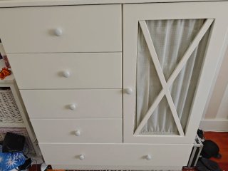 Cómoda infantil blanca con puerta.