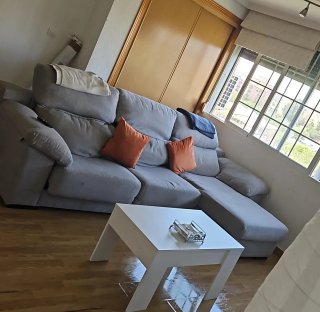 Sofá chaise longue gris con cojines