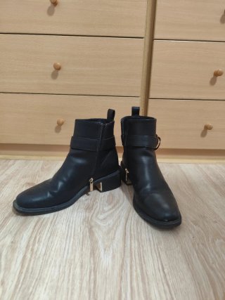 Botines negros con hebilla y cremallera.