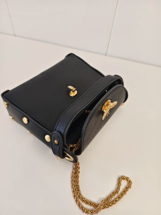 Bolso negro con detalles de abeja dorada y otros