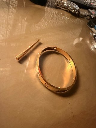 Pulsera dorada con tornillos y piedras