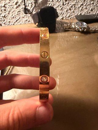 Pulsera dorada con tornillos y piedras