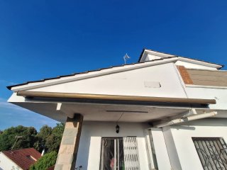 Toldo motorizado beige y verde con mando