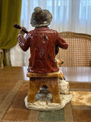 Figura hombre tocando laúd y perro