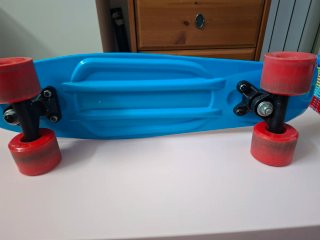 Monopatín azul con ruedas rojas