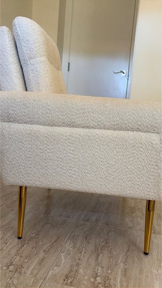 Sillón de tela beige con patas doradas