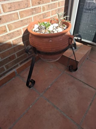 Maceta de terracota con soporte de metal