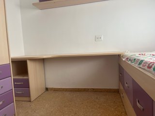 Habitación juvenil con cama y escritorio.