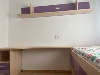 Habitación juvenil con cama y escritorio.