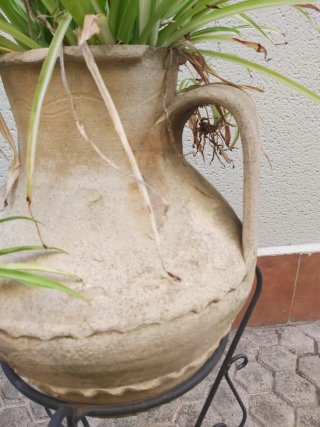 Tinaja de barro con plantas y macetas varias
