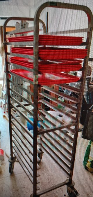 Carro de panadería con bandejas rojas