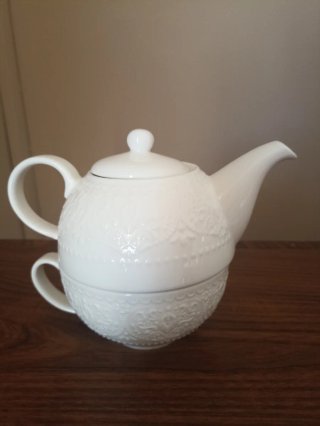 Teiera e tazza in porcellana bianca.