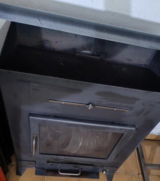 Estufa, chimenea de leña negra con detalles dorado