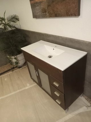 Lavabo con mueble de madera y cristal