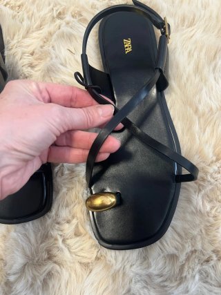 Sandalias planas negras con detalle dorado