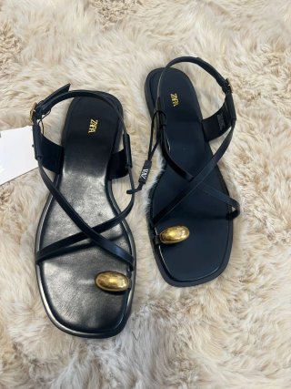 Sandalias planas negras con detalle dorado